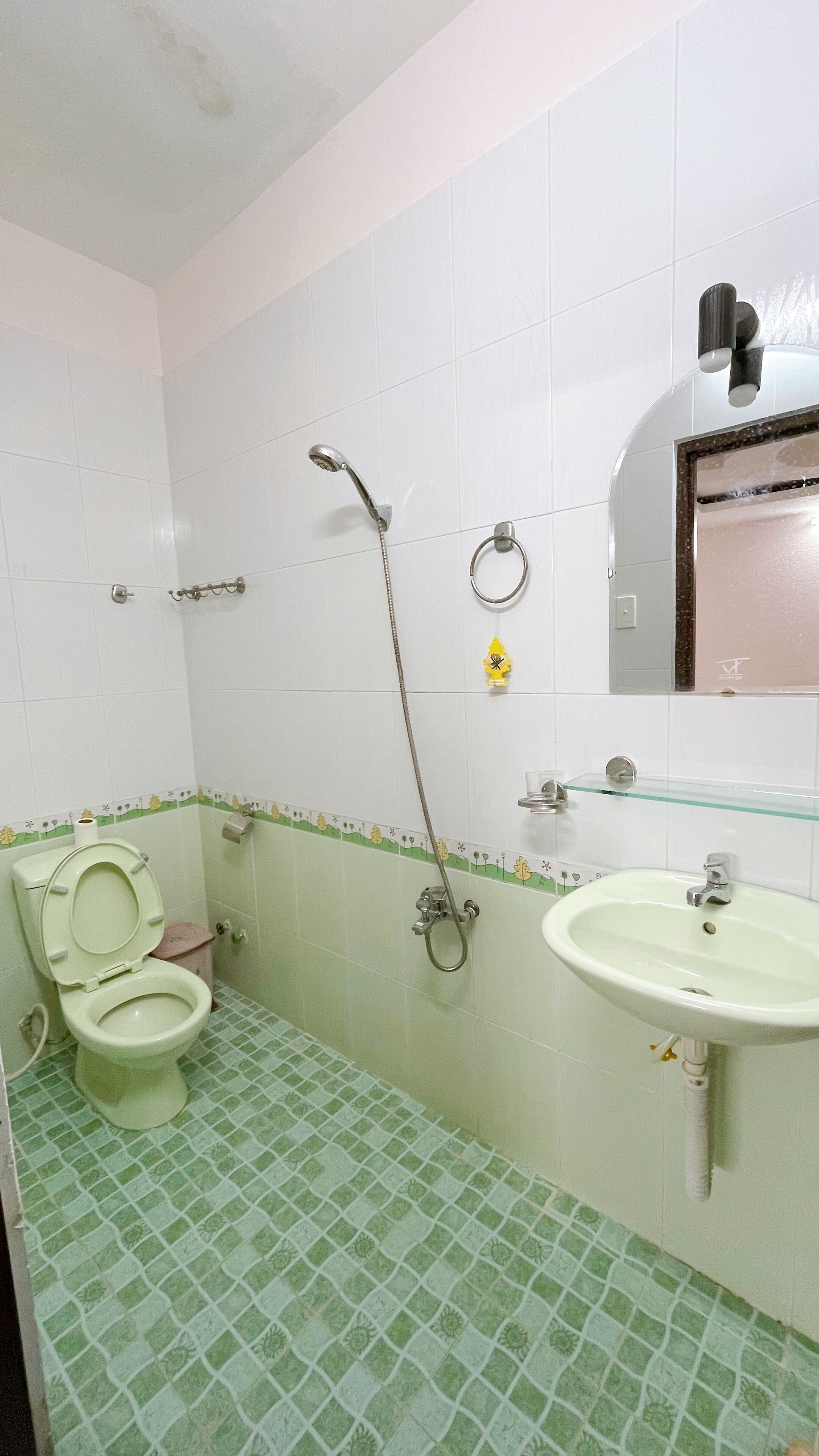 A bathroom with a toilet, a shower, and a sink.