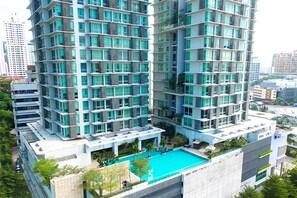 Un edificio residenziale alto con numerosi balconi e una piscina sul tetto.