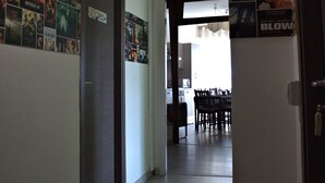 A hallway with a door labeled "SPY ROOM," a dining area with chairs and a table, and a wall decorated with movie posters. - Movie Home B&B (Rome)