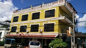 Un edificio de dos pisos con un letrero que dice 'Chanthasom Guest House'.