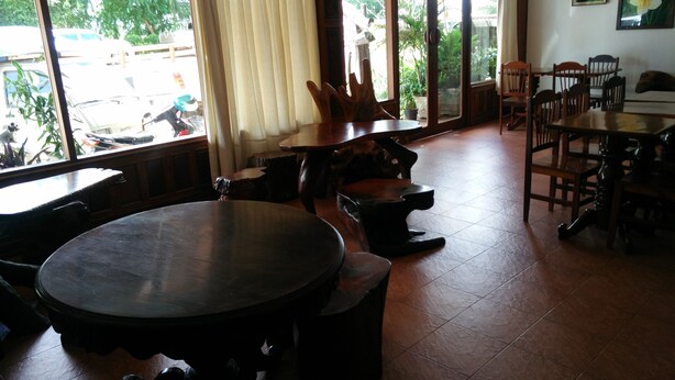 Un comedor con una mesa redonda, bancos y sillas. Se ve una ventana con vistas al exterior.