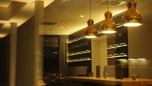 Un intérieur moderne agrémenté de luminaires suspendus, d’un bar et d’un porte-bouteilles fixé au mur.