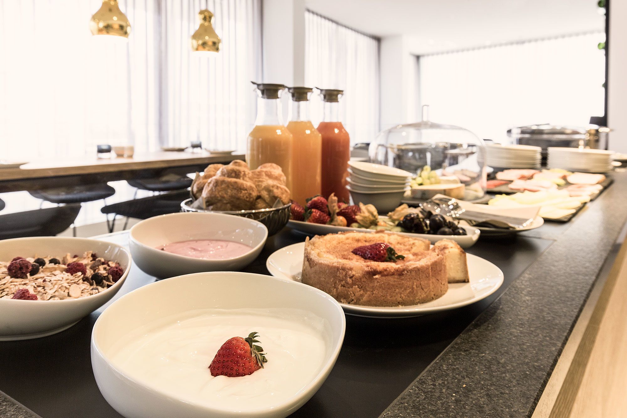 Un buffet proposant une variété de plats, notamment des fruits, des pâtisseries et des boissons.