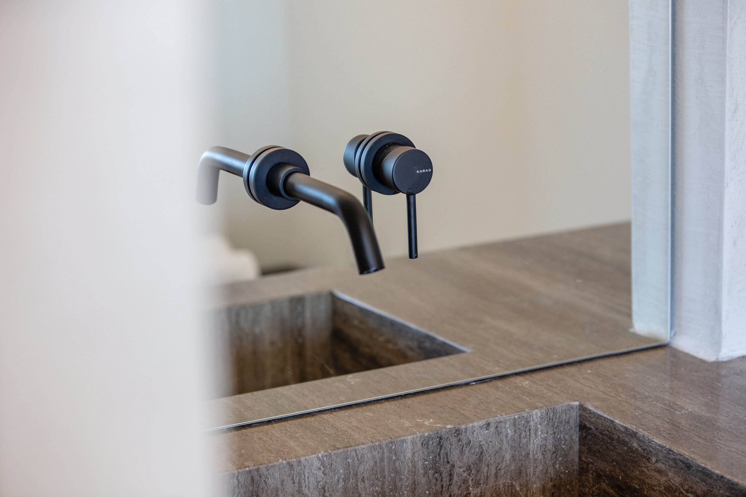 Un baño moderno con un grifo metálico elegante y un lavamanos rectangular.