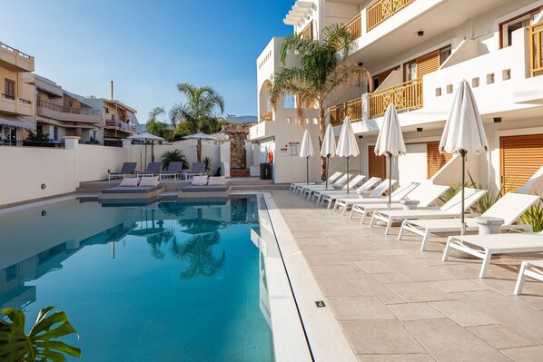 حمّام سباحة خارجي، مظلات على حمّام السباحة، مقاعد للتشمس