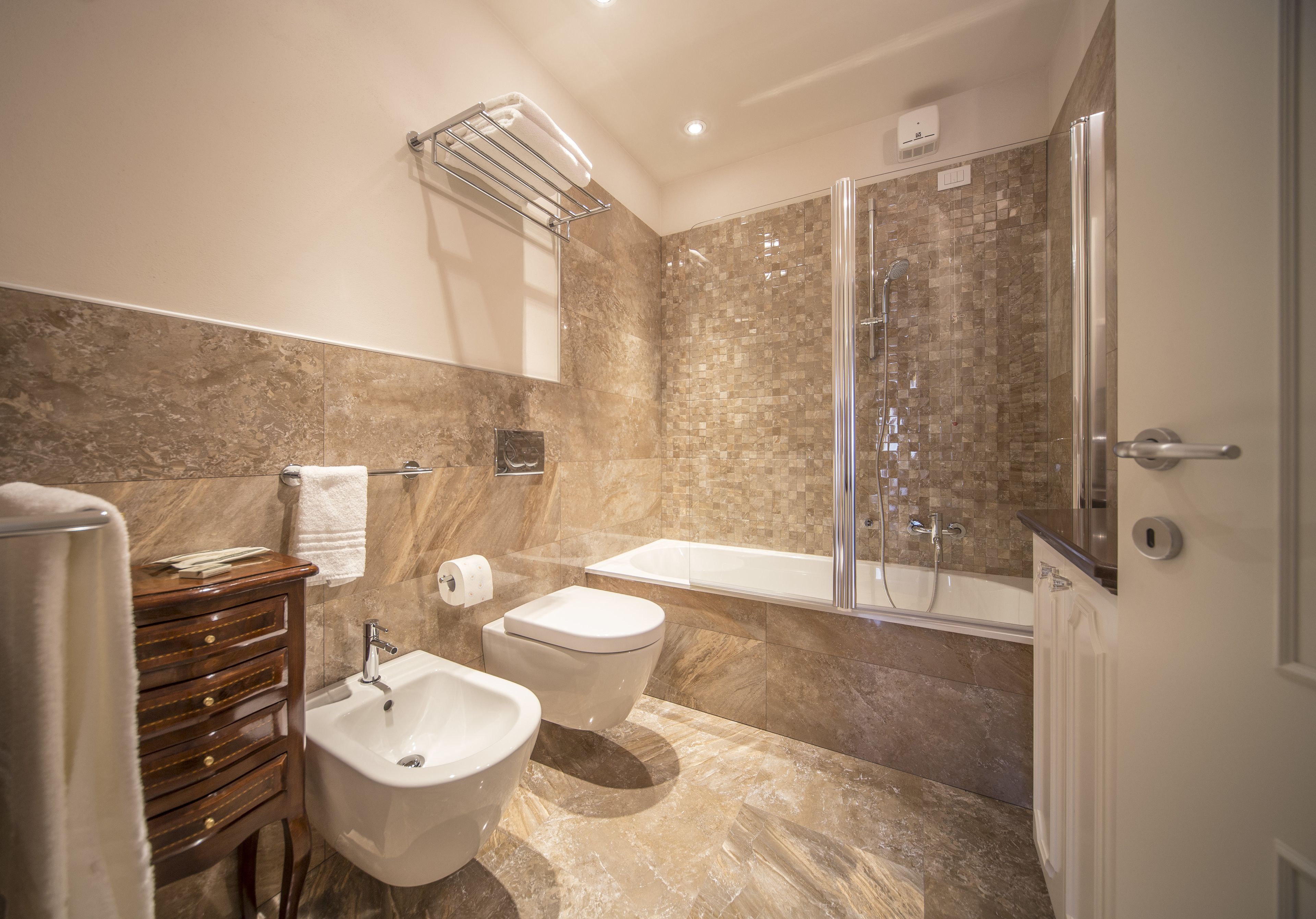 Ein modernes Badezimmer mit einer Bidet-Funktion, Toilette und Badewanne.