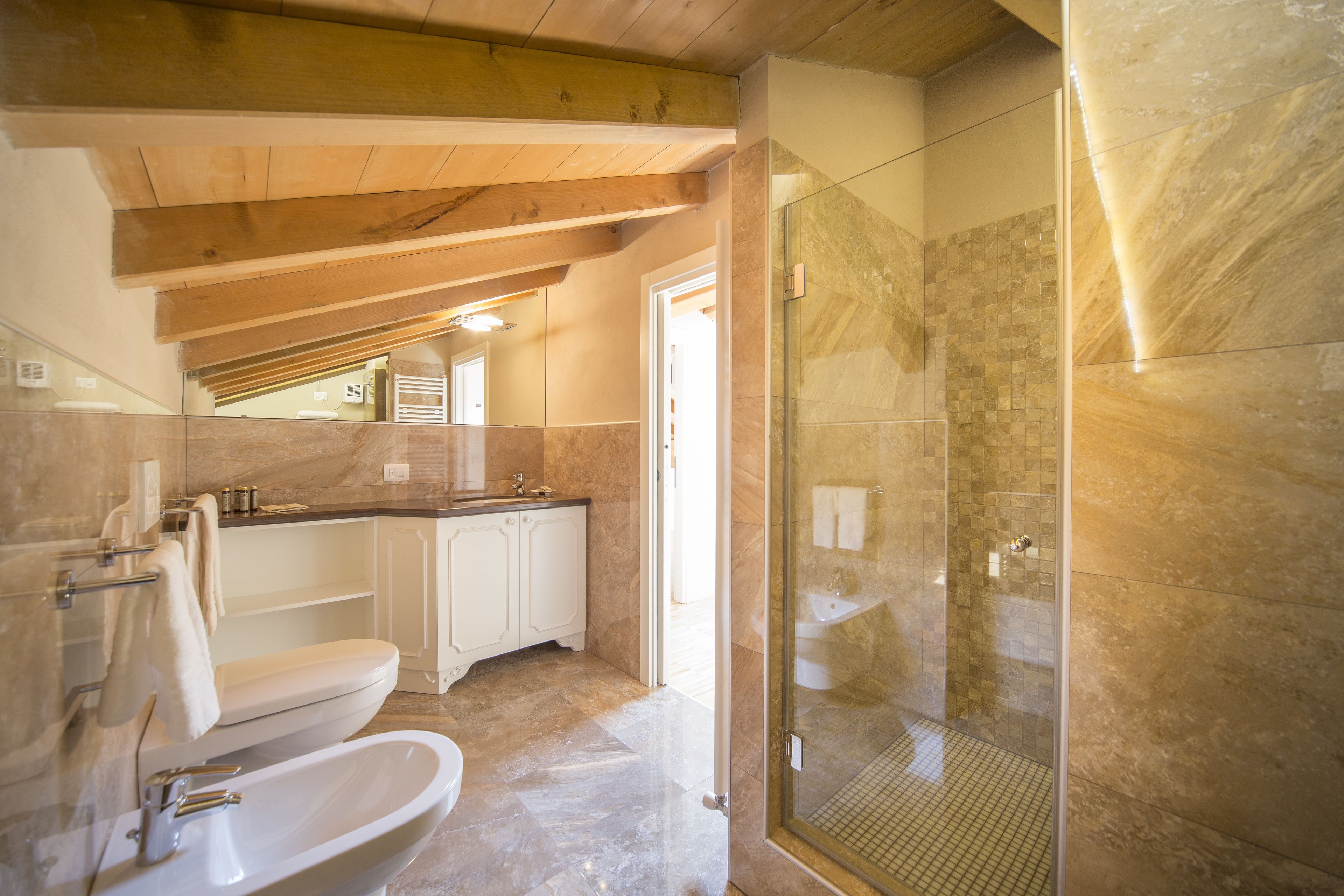 Une salle de bain moderne avec une douche à parois de verre, un lavabo blanc et un meuble-lavabo avec un miroir.