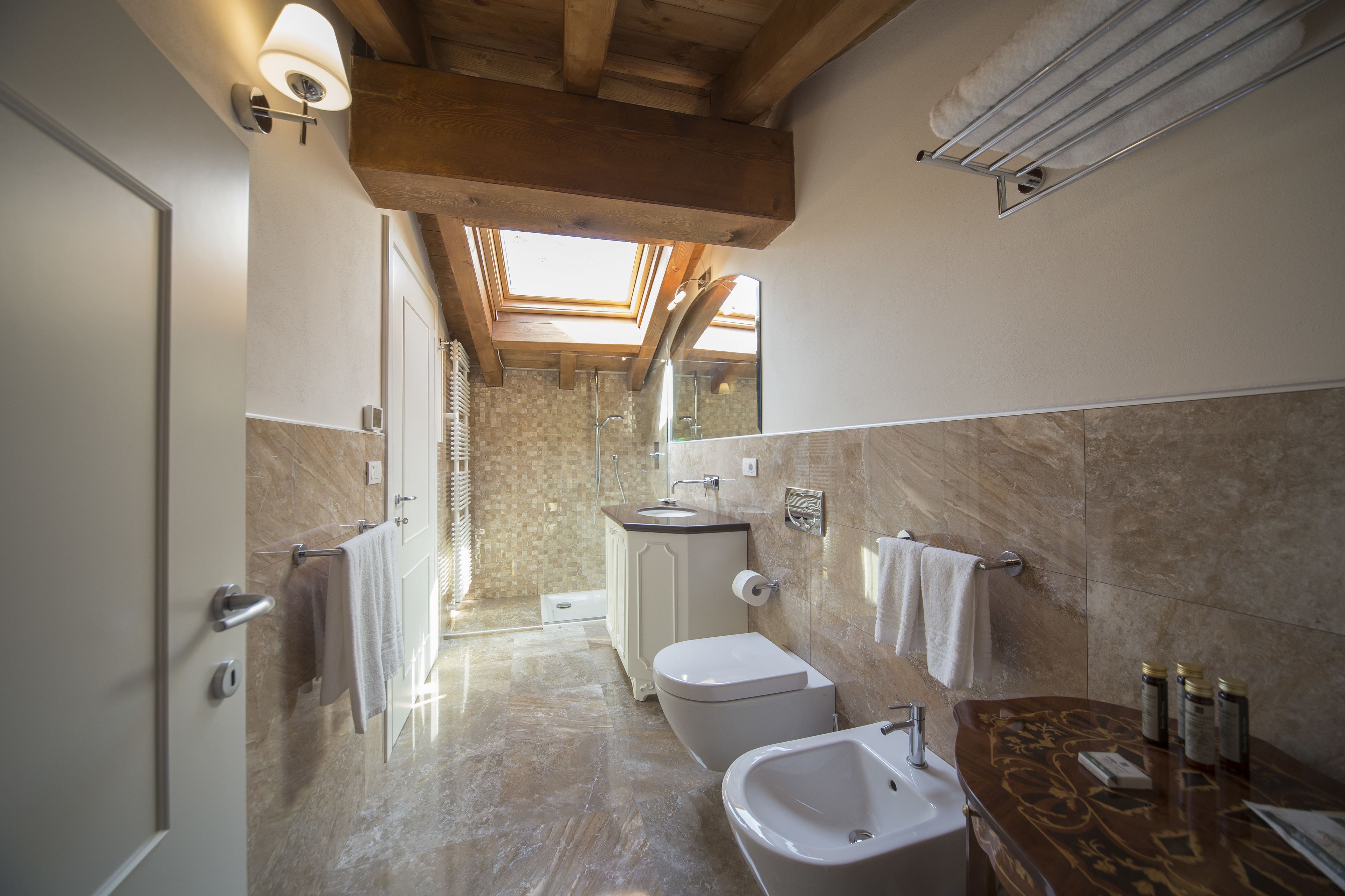 Un baño moderno con tragaluces, una bañera, un lavamanos y un inodoro.
