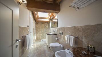 Un baño moderno con tragaluces, una bañera, un lavamanos y un inodoro.