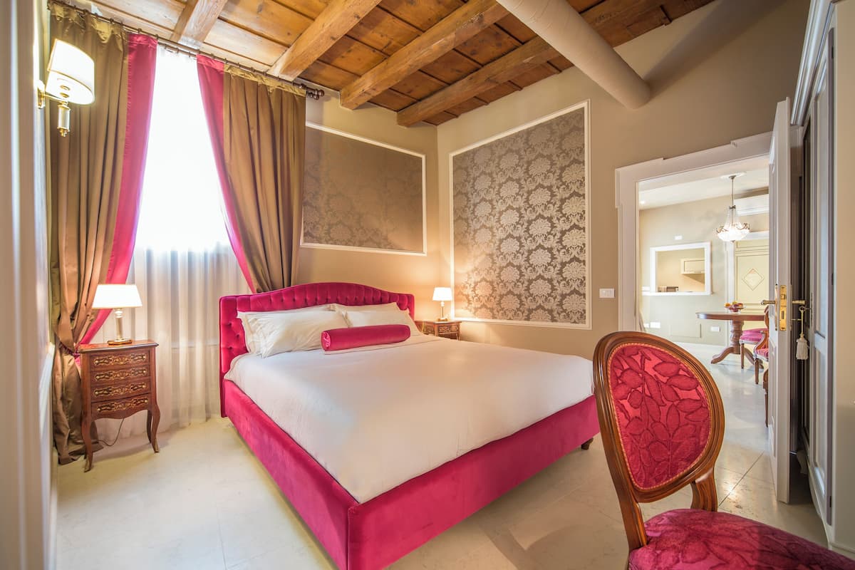 Un dormitorio con una cama grande, cabecera de madera y una silla roja.