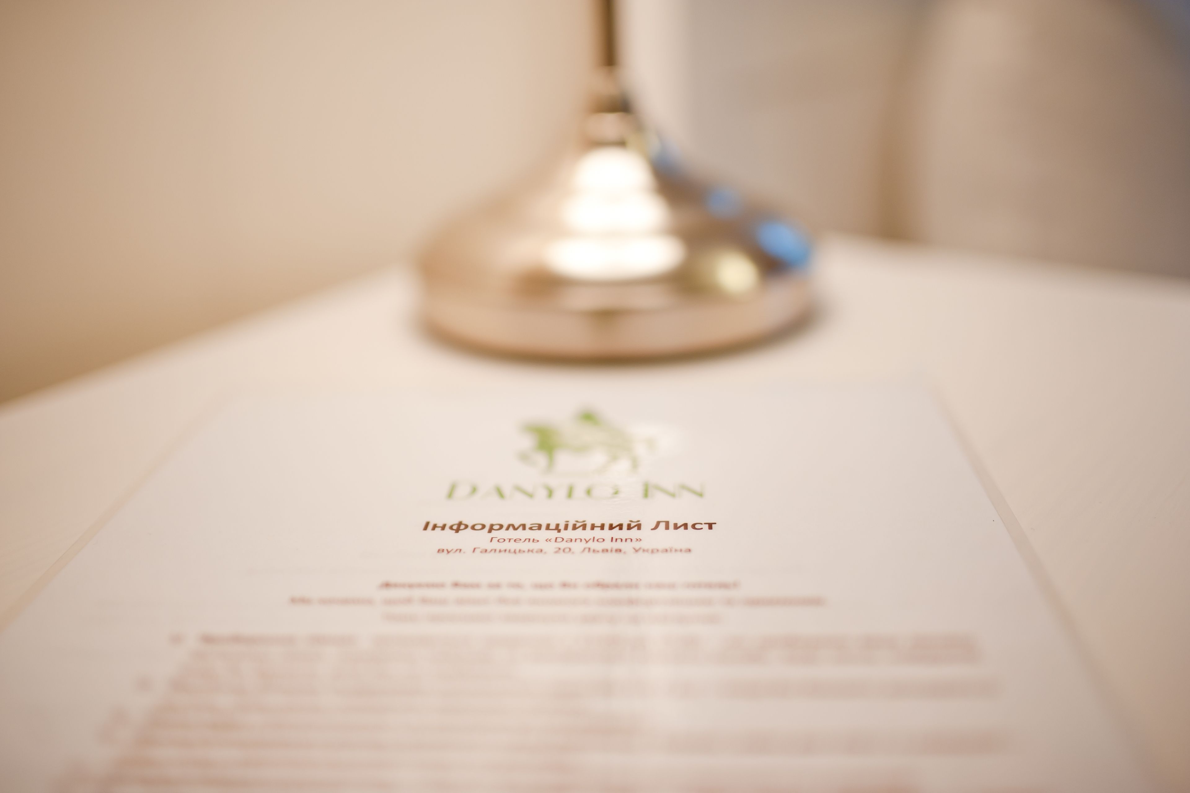 A blurred hotel brochure with the name "DANILO INN" and a location in Lviv, Ukraine.