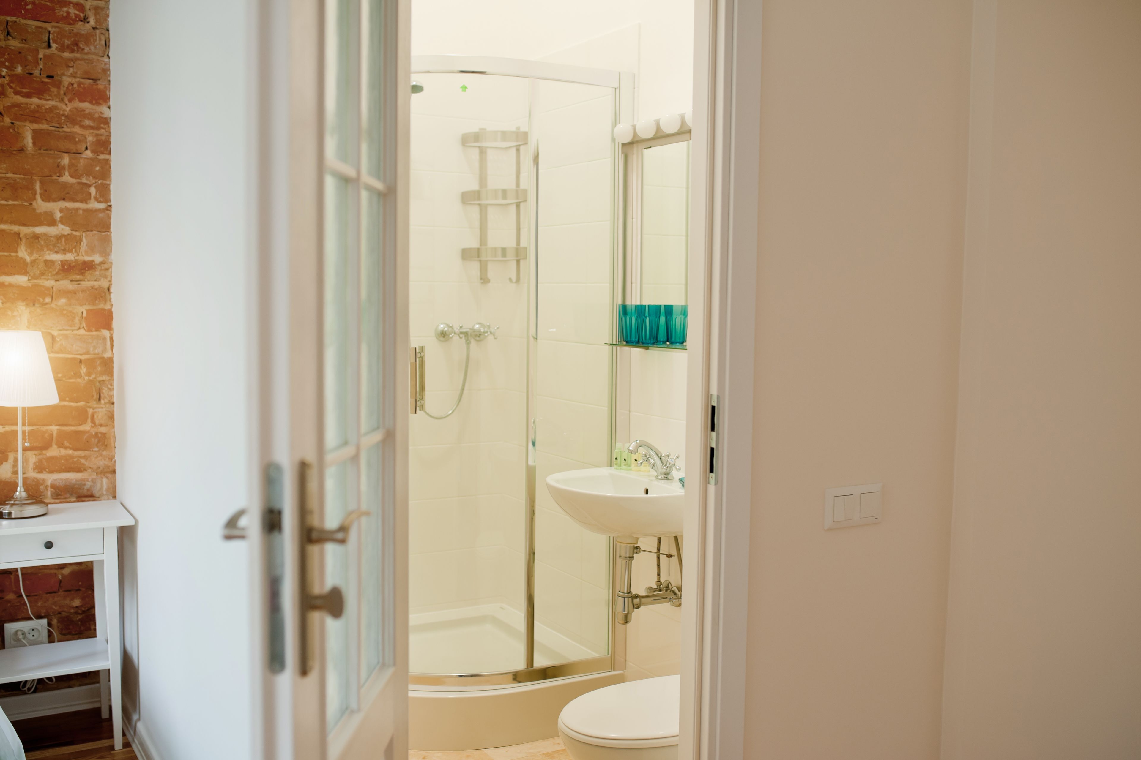 Un baño con cabina de ducha de vidrio, lavamanos blanco y retrete.