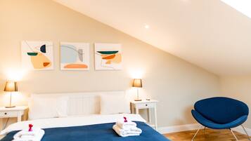 Habitación de hotel con una cama, dos mesitas de noche, una silla y un cuadro abstracto en la pared.