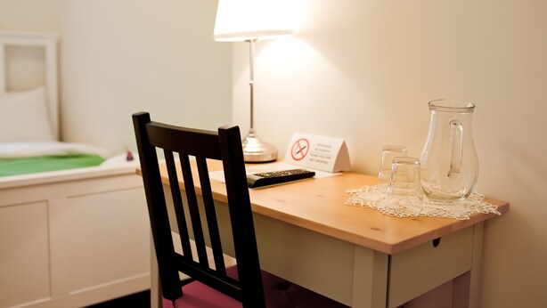 A wooden desk with a lamp, a sign, and a pitcher. - Danylo Inn (Lviv)
