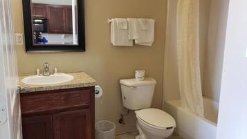 A bathroom with a sink, toilet, and bathtub.