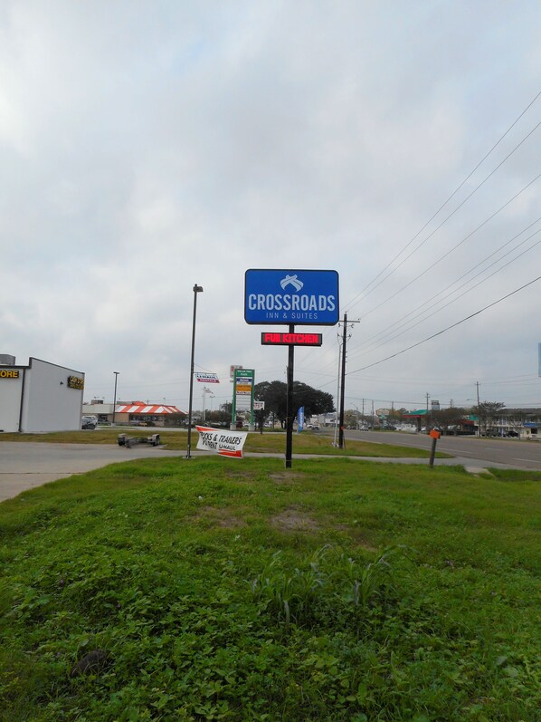 A sign for Crossroads Inn & Suites with a 'Full Kitchen' sign below it.