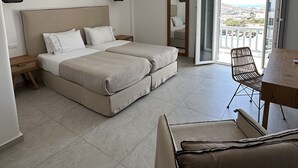 Una habitación de hotel moderna con una cama grande, un escritorio y un balcón con vistas.