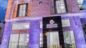 A multi-story boutique hotel with a stone facade, large windows, and a prominent entrance with signage. - Erdem City Hotel (Kas)