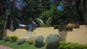 A gated property with a sign for "Monivise Villas" and a paved walkway. - Moon Rooms at Moonrise Villa (Negril)