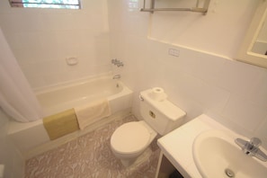 A bathroom with a bathtub, toilet, and sink.