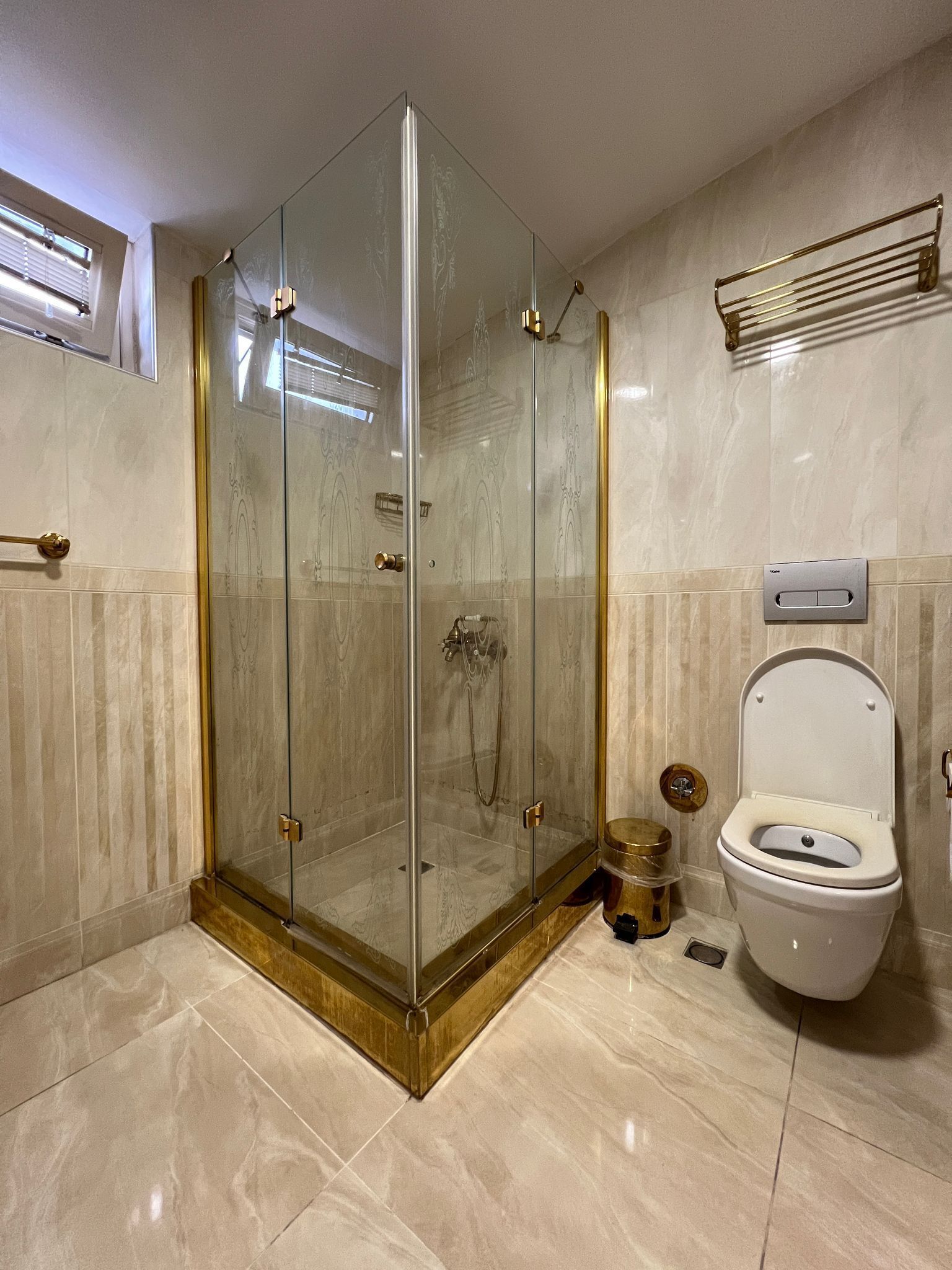 A modern bathroom with a glass-enclosed shower, a toilet, and a vanity with a sink.