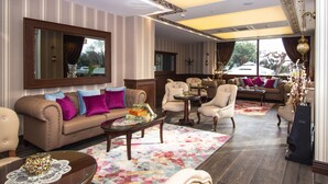 A spacious living room with a large sofa, armchairs, a coffee table, and a TV. - Le Marde Hotel (Istanbul)