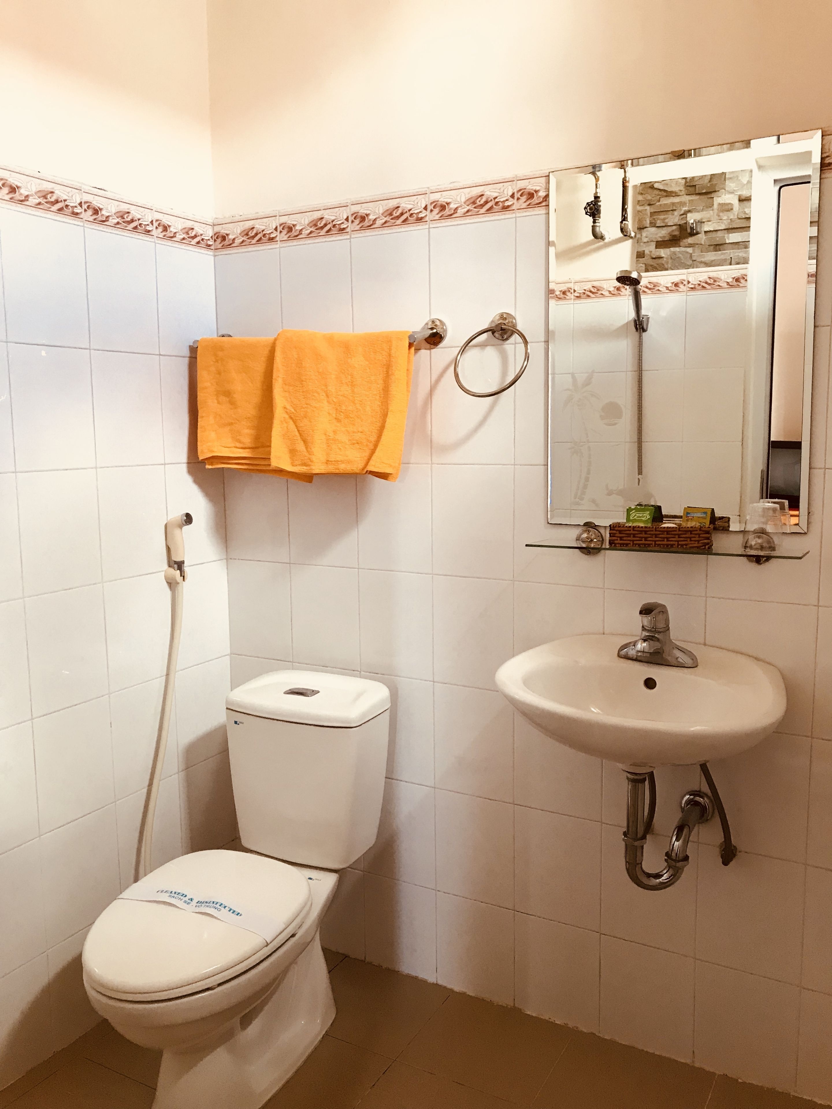 A bathroom with a toilet, sink, and shower.