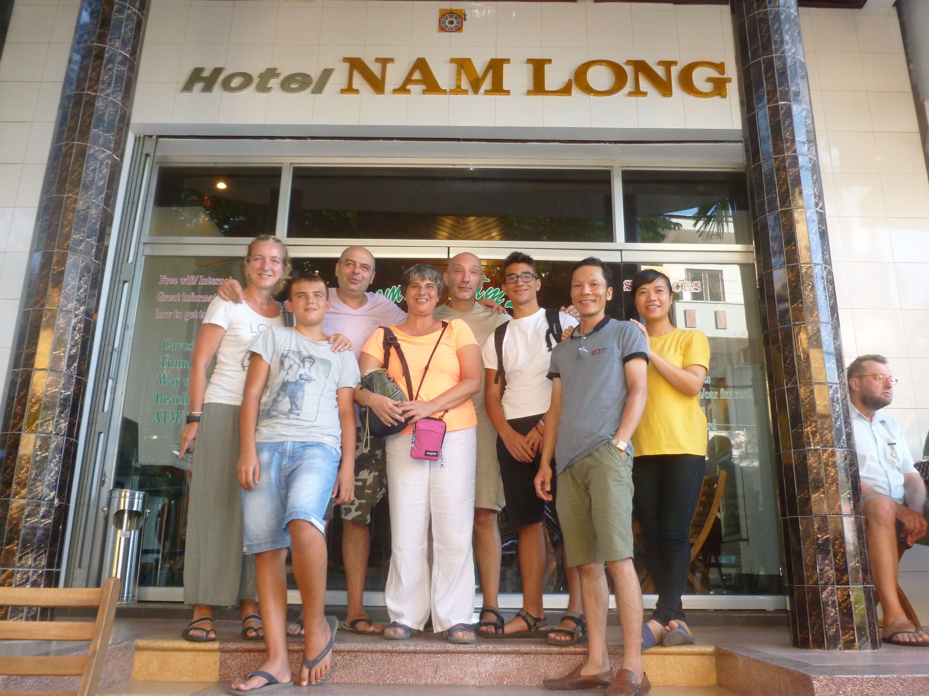 A group of people posing in front of Hotel Nam Long.