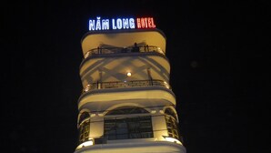 Un edificio de varios pisos con un letrero que dice 'NAM LONG HOTEL'.