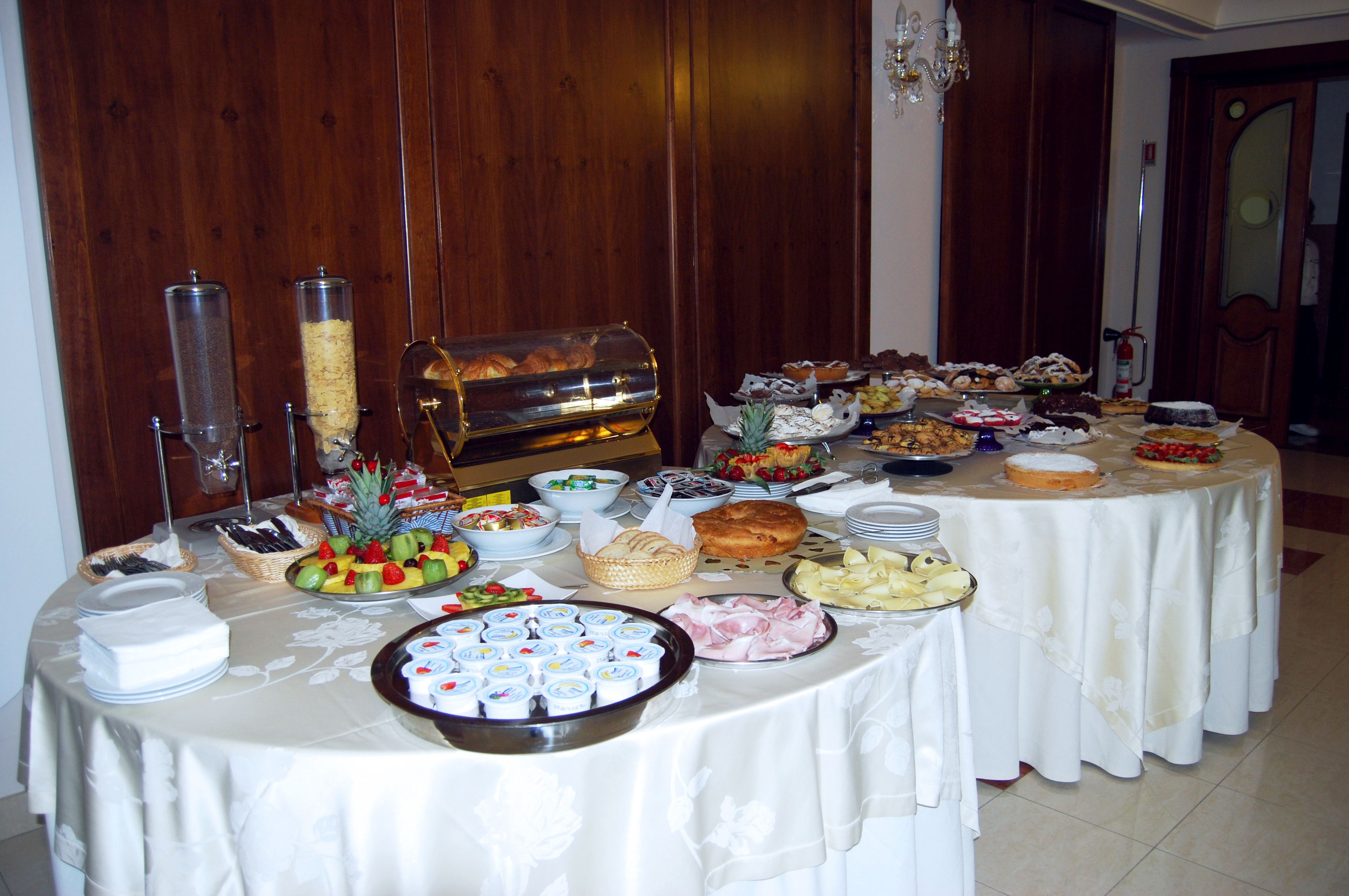 Une table de buffet proposant divers plats et un coin café.