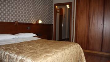Una habitación de hotel con una cama grande, un armario de madera y una pared con diseño.