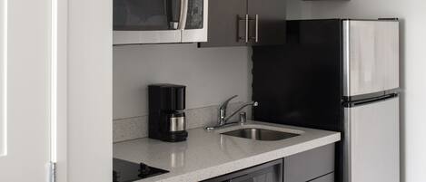 A modern kitchen with stainless steel appliances, a dishwasher, and a coffee maker.