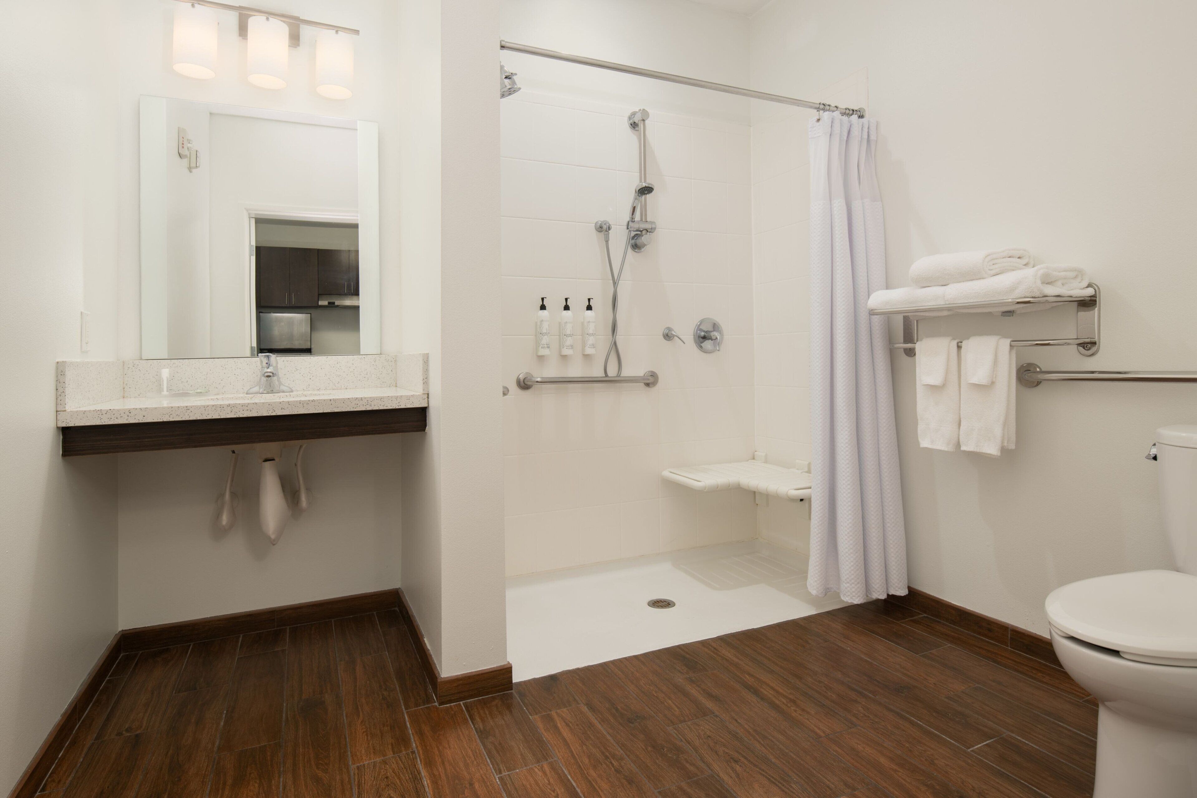 A modern bathroom with a shower, toilet, and sink.