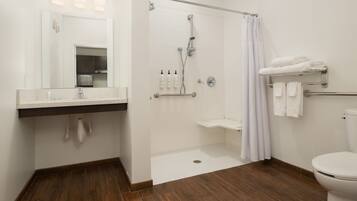 A modern bathroom with a shower, toilet, and sink.