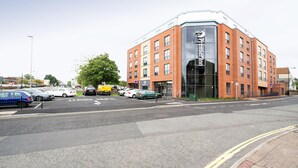 A multi-story building with a prominent entrance and a parking lot in front. - Premier Inn Basingstoke Town Centre (Basingstoke)