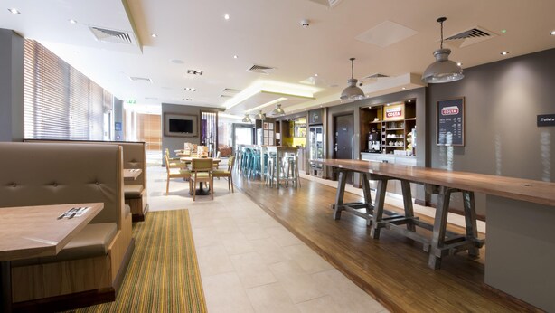 Un hall d’hôtel moderne, doté d’espaces détente, d’un bar et d’un café Costa.