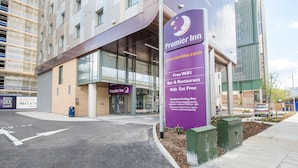 A Premier Inn hotel entrance with a signboard, a parking area, and a modern building in the background. - Premier Inn London Brentford (Brentford)