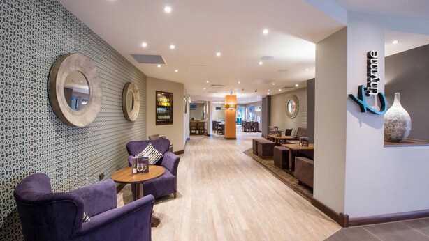 A hotel lobby with seating, a reception desk, and a patterned wall. - Premier Inn London Brentford (Brentford)