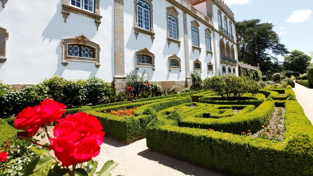 A historic building with symmetrical architecture, manicured gardens, and a clear sky. - Parador Casa da Insua (Penalva Do Castelo)
