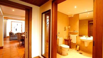 A bathroom with a toilet, sink, and mirror.