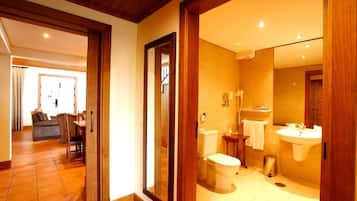 A bathroom with a toilet, sink, and mirror.