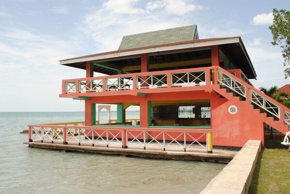 A multi-level building with balconies, a staircase, and a view of the water.
