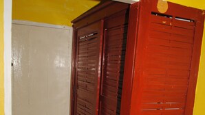 A room with a yellow wall, a white door, and a red door. - Bluefields on the Bay (Bluefields)