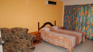 Quarto com cama, sofá e cortina.