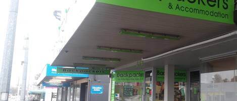 A storefront with a green sign reading "Backpackers & Accommodation".
