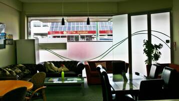 Ein moderner Arbeitsbereich mit Sofa, Stühlen, einem Couchtisch und Blick auf ein Gebäude mit der Aufschrift "The Gulmohar".