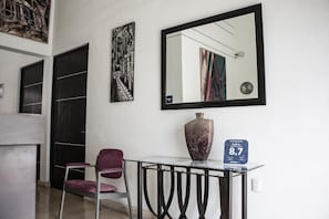 A hotel lobby with a modern design, featuring a marble table, a large mirror, and artwork on the walls. - Hostel Viatger Inn (Campeche)