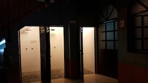 Un passadís amb una escala que condueix a un bany amb dutxa i vàter.