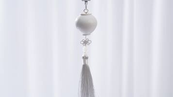 A white tassel hanging from a keychain.