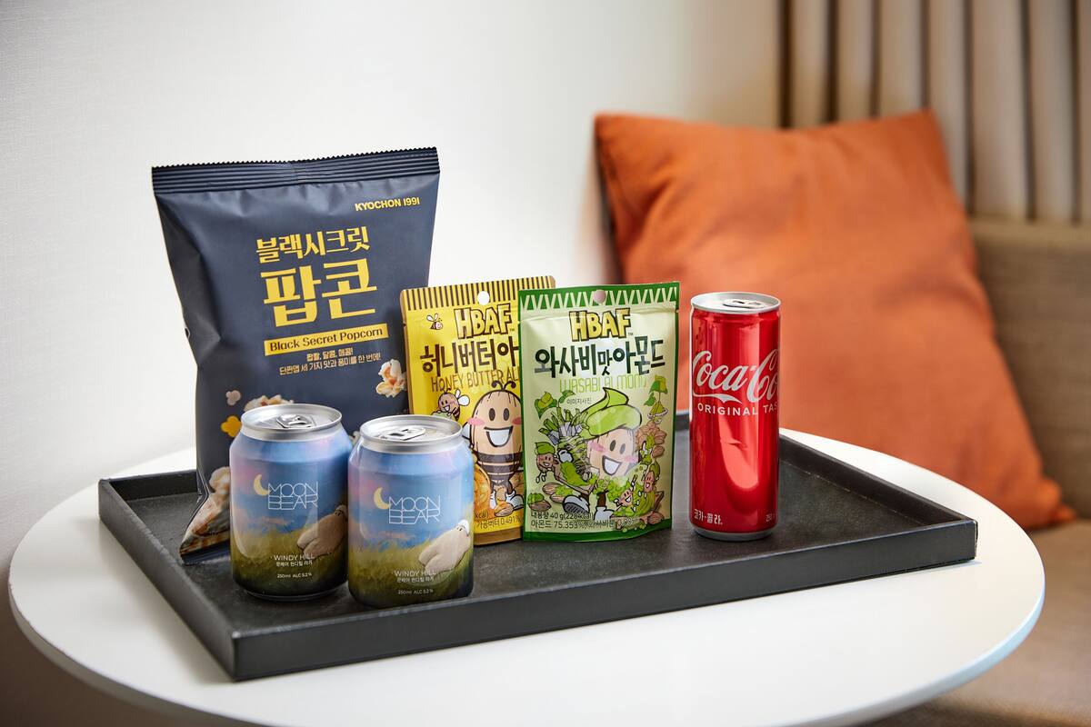 Un plateau contenant des en-cas, des boîtes de conserve et une canette de soda, posé sur une table.